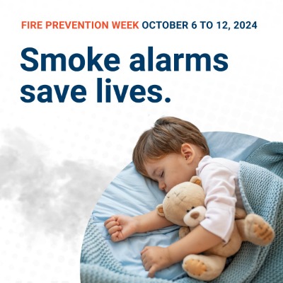 Fire Prevention Week October 6 to 12, 2024. Smoke alarms save lives. Image: Small child asleep in their bed.