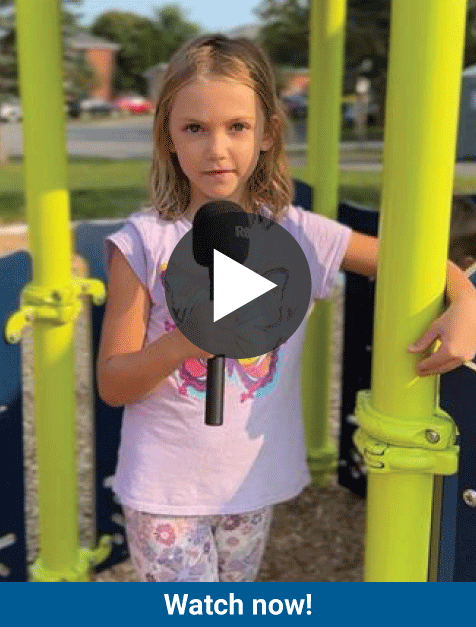 Video thumbnail - Child with a microphone at the playground. Text: Watch now with play button above