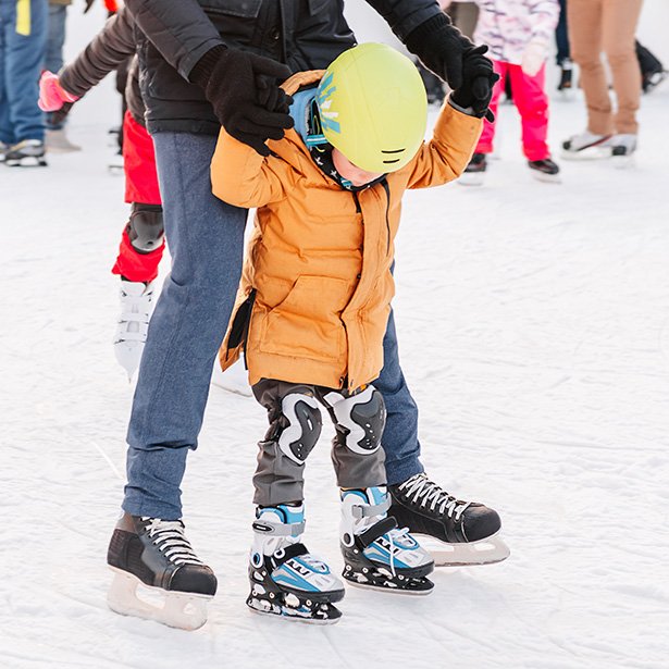 Image of an adult helping a child to learn to skate.