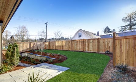 Backyard surrounded by wooden fence.