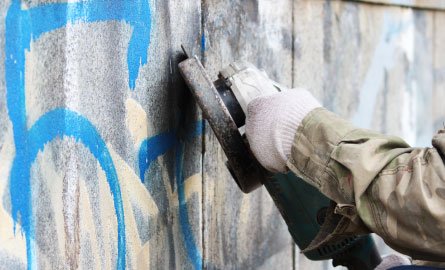 Removal of graffiti on a concrete wall with the help of a angle grinder.