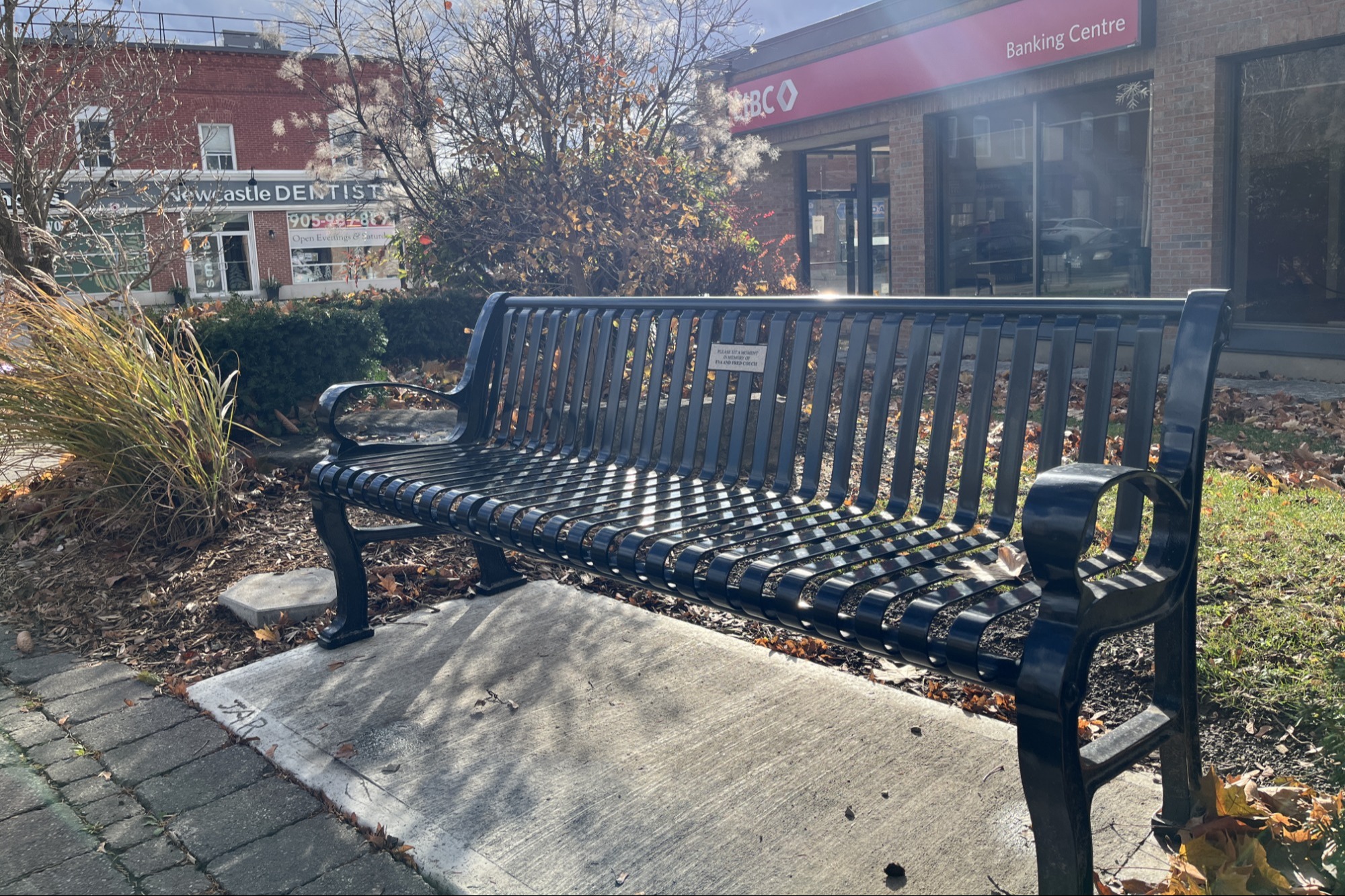 Picture of park bench with a bouquet of flowers on it.