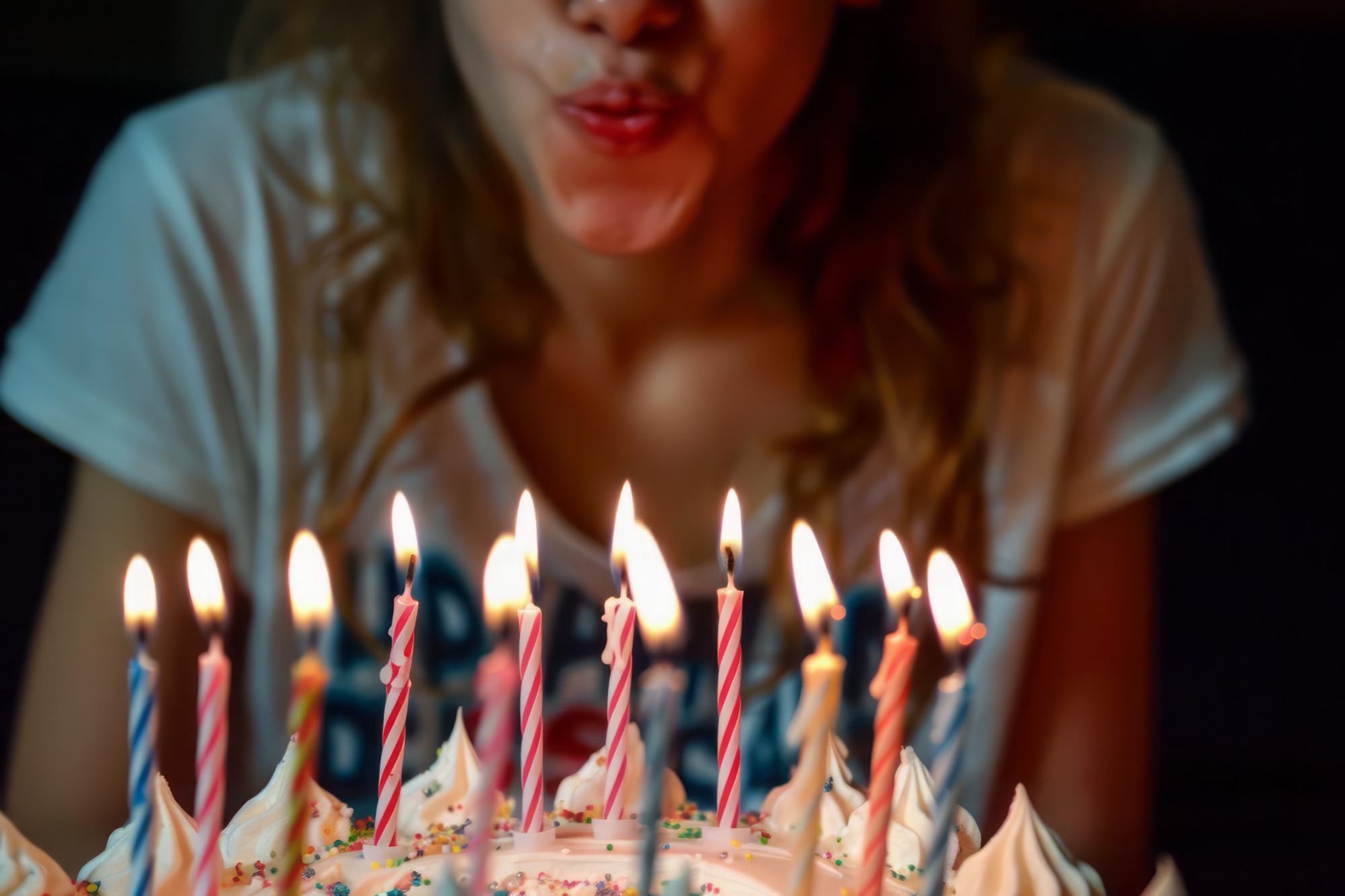 Picture of someone blowing out the candles of a birthday cake.