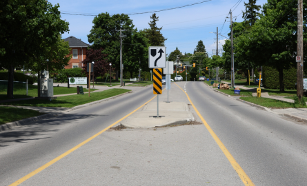 A median island on a street with lanes on either side.