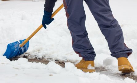 Close up photo of a person shoveling snow. 