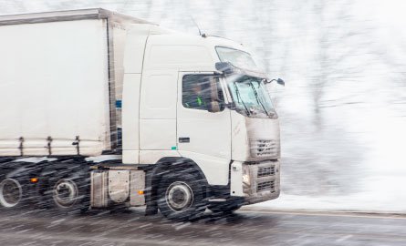 A large truck on a wintery street.